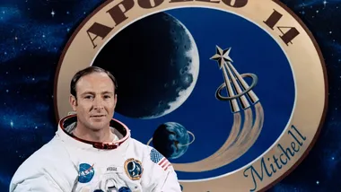 Астронавт Едгар Д. Мітчелл на фоні емблеми Аполлона-14. Фото NASA